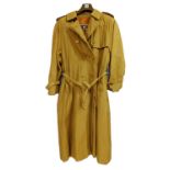 A lady's double breasted Burberry trench coat, in green check with brown buttons, belted waist and