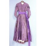 A lady's late Victorian purple check day dress, with button front, full skirt, sash waist, braided