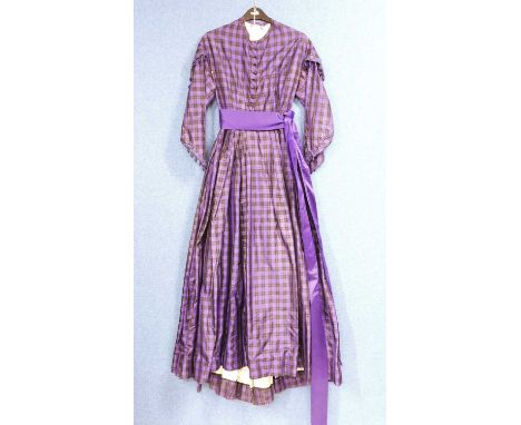 A lady's late Victorian purple check day dress, with button front, full skirt, sash waist, braided and tassel trim to sleeves