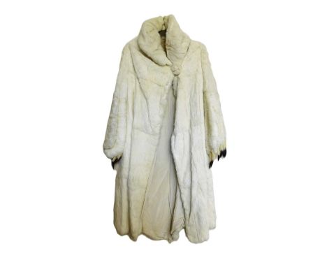 A lady's full length cream fur coat, with high turn up collar and balloon cuffed sleeves with ermin trimsome mottling through