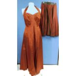 A ladies burgundy halter neck evening gown with fitted ruched bust, zip back together with