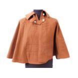 An early 20th century lady's brown felt cape, with double buckle fastening to neck and portcullis