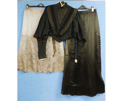 A lady's late Victorian black jacket with high neck and lace trim, deep V neck front with black lace, leg of mutton sleeves w