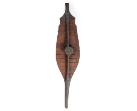 A 19th Century Nias War Shield, Sumatra, of light Sagow wood reinforced with horizontal bands of twisted rattan, the raised m