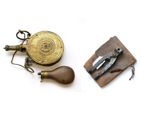 A 17th Century North European Brass Powder Flask, of circular form, each side applied with double C scrolls on a foliate engr