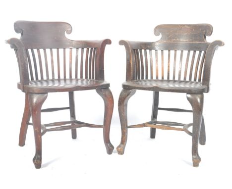 A pair of early 20th Century oak and mahogany bankers chair / captains desk chairs / armchairs having a shaped scroll back wi