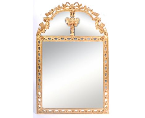 A 19th Century gilt gesso pier / overmantel mirror having an arched architectural top with ribbon and leaf decoration, grape 