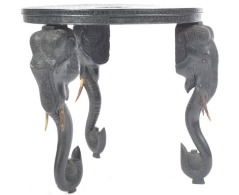 An early 20th Century Anglo Indian Colonial inlaid elephant side occasional table of round form. The top heavily carved havin