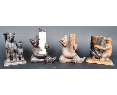 A collection of four 19th Century German Black Forest carved bears comprising a seated bear figure holding a thermometer, ano