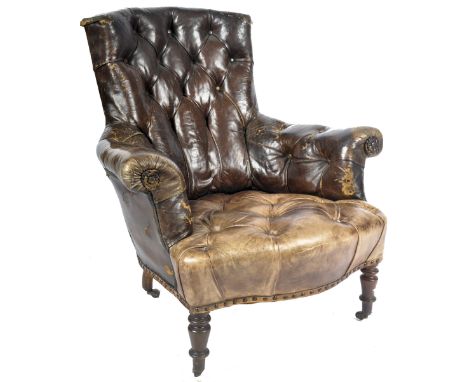 A 19th Century Victorian well weathered brown leather button back library / gentlemans club armchair having a shaped backrest