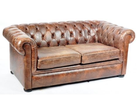 A contemporary Chesterfield two seater sofa settee in weathered brown leather with button back backrest and scroll arms. All 