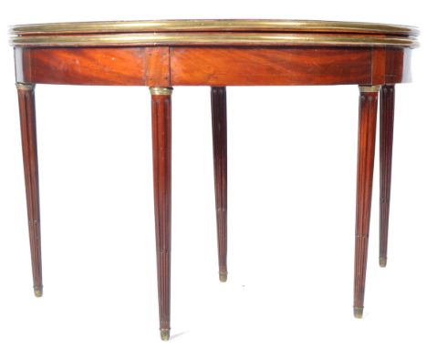 An early 20th Century French Empire mahogany and brass card table / games table of demi lune shape having brass borders to th