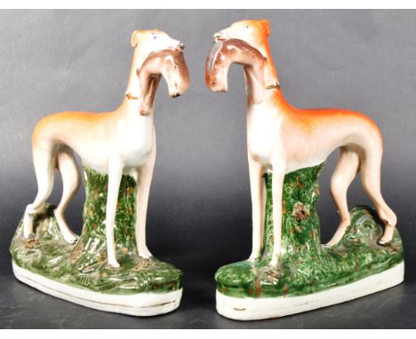 A matching pair of 19th Century Victorian Staffordshire hand painted figures in the form of standing sporting hounds / huntin