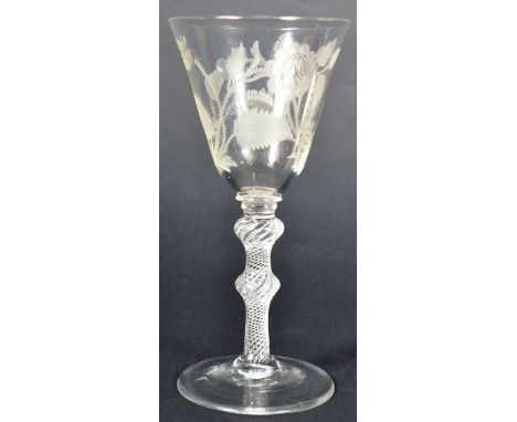 A mid 18th Century Jacobite wine drinking glass having a bell shaped bowl engraved with a rose and two buds on a thorny stem,