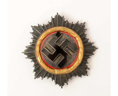 A WWII German Cross, in gold, with black enamel swastika and gilt wreath with some red enamel, the pin stamped 20.