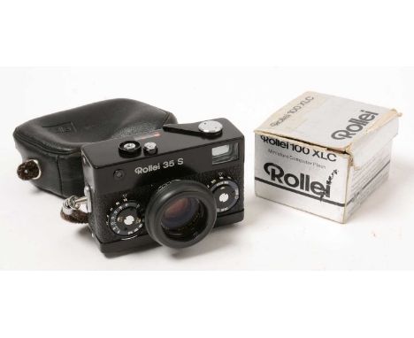 A Rollei 35S camera in black, with flashgun, manual and filters.