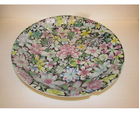 Large Chinese porcelain dish enamelled in the famille rose palette against a black ground with numerous and various flowers, 