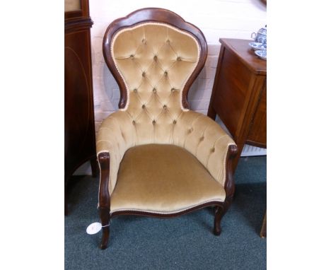 A ladies spoon button back armchair upholstered in old gold velvet fabric