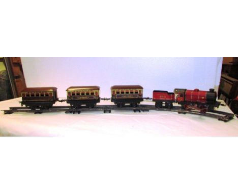 A Hornby gauge '0' tinplate clockwork engine and tender with three Pullman carriages and rail (in working order)