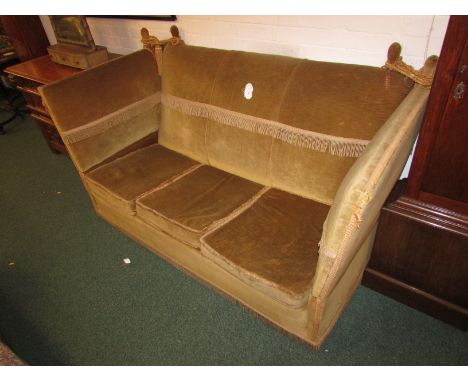 High backed Edwardian Knoll sofa in gold coloured upholstery with tasselled fringes, on ball castors (height 92cm width 172cm