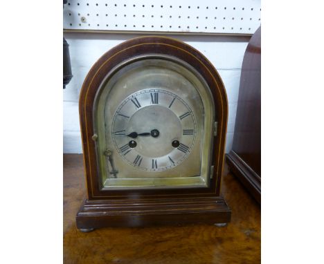 An Edwardian mahogany boxwood strung dome shaped striking mantle clock with silvered minute Roman interval chapter ring, worn