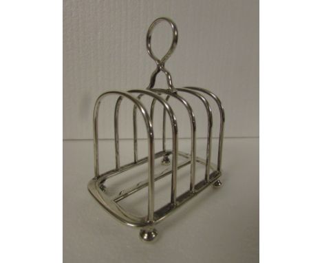 Silver four division toast rack with hoop finial on bun feet, marks for Sheffield, 1915, maker's stamp Walker & Hall, (3.9 oz