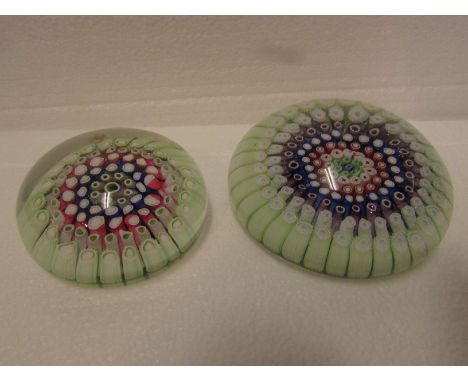 Two paperweights - the larger with a broad outer ring of pale green canes and rings of mauve, blue and red within, indented b