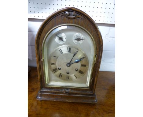An Edwardian oak dome shaped striking mantle clock with subsidiary slow / fast and silent / chime dials. The Roman numerals w