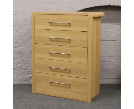 A modern light oak effect chest of five drawers, 116cm high, 90cm wide, 48cm depth.