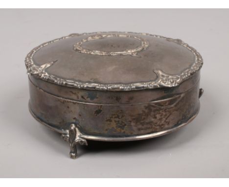 An early 20th century circular silver trinket box, raised on fleur de lys feet, assayed Birmingham.