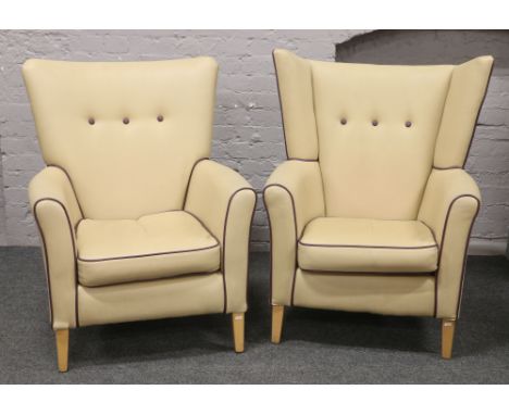 Two vinyl arm chairs with deep button and purple piping upholstery.