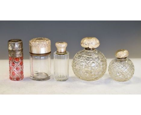 Five assorted cut glass toiletry jars to include; a ruby-flashed example, two clear spherical examples and two further cylind