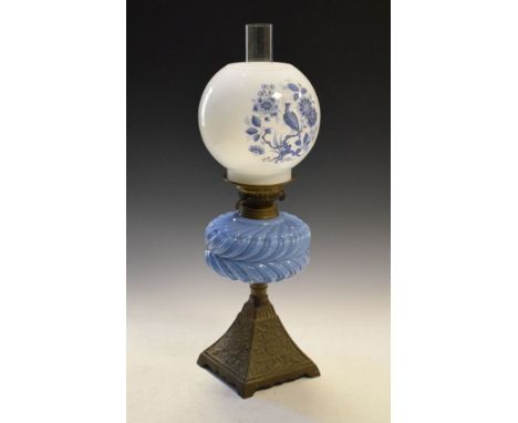 Late Victorian cast iron and opaque glass paraffin lamp having a gadrooned glass reservoir on pyramidal base with white glass