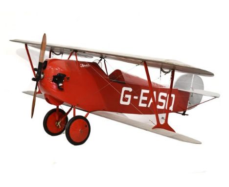 Impressive large scale model petrol-powered bi-plane with wooden propeller, silver-coloured wings and tail, and red body lett