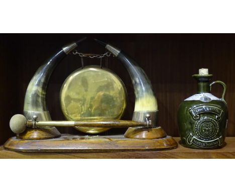 A late-19th/early-20th century table gong with beater, modelled with horn supports suspending the brass circular gong, with p