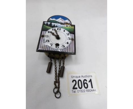 A miniature enamel faced Grandfather clock movement wall clock (no key or pendulum).