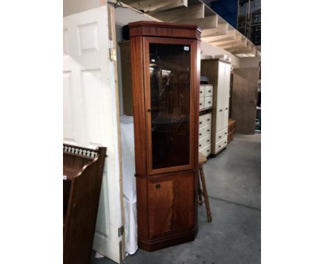 A light mahogany effect corner cupboard