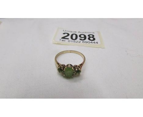 A 9ct gold ring set three peridot, size O half.