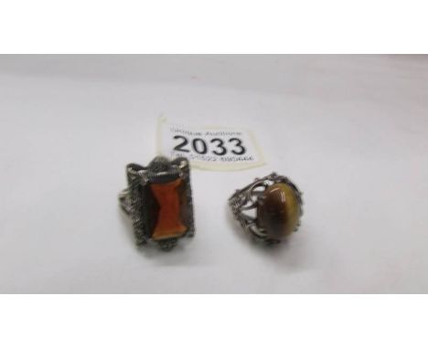 A silver ring set Tiger's eye and another silver ring set amber coloured stone.