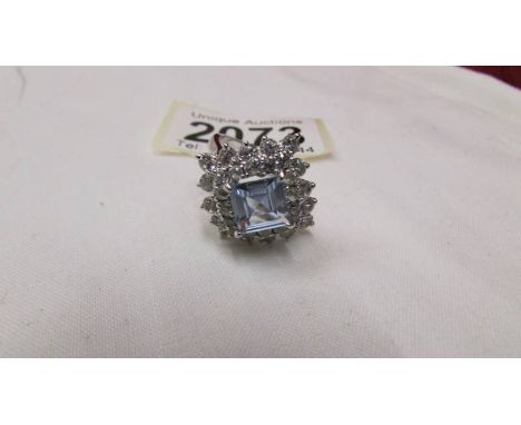 A cluster ring set with white stones and centre blue stone in white metal. Size N half
