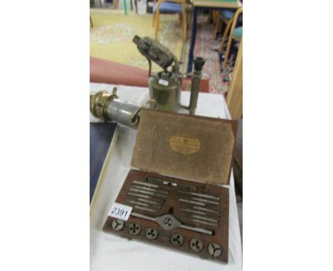 A set of taps and dies, a brass blow lamp and a vintage fire hose head (purportedly from Cadbury Frys, Keynsham).  (collect o