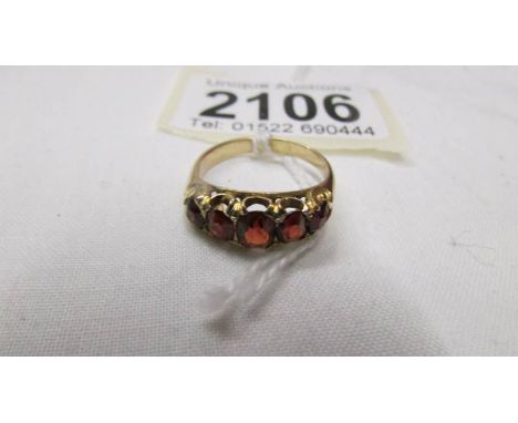 A yellow metal ring set red stones, size M half. (Tests as 18ct gold)