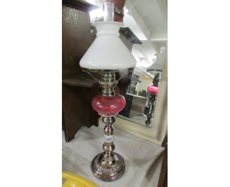 A telescopic 'candlestick' oil lamp with cranberry glass font.  (collect only).