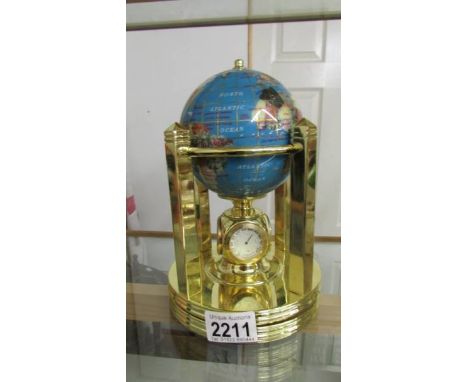 A gemstone globe weather station with clock and thermometer.