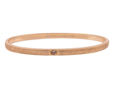 De Beers - a hinged bangle in 18ct yellow gold, featuring a polki diamond gypsy-set to the front, the textured D-shaped bangl
