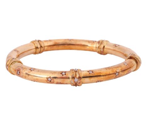 A diamond-set hinged bangle in 18ct yellow gold, constructed in two halves with roundels, star-set with diamond accents throu