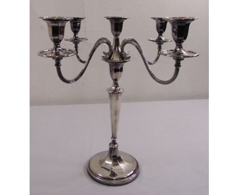 A five light silver candelabrum of tapering cylindrical panelled form with detachable scrolling arms on raised circular base,