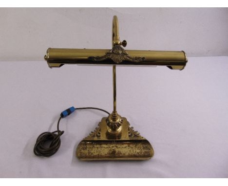 A brass desk lamp and pen stand on triform base