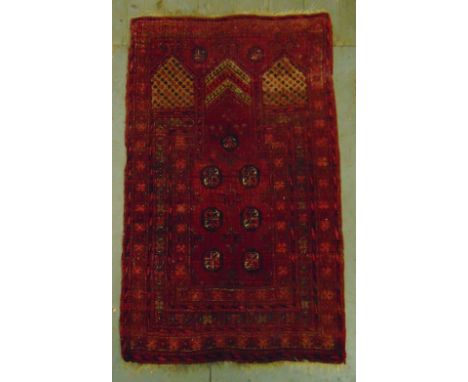 A Middle Eastern wool carpet red ground with repeating geometric patterns, 121 x 75.5cm