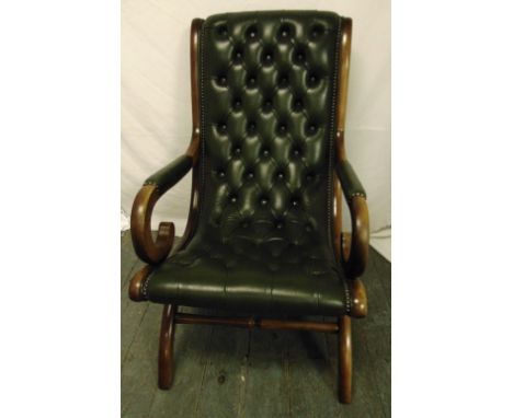 A mahogany and green leather occasional chair with scrolling arms and legs